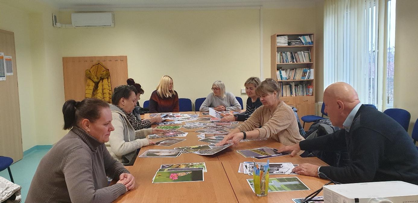 Zdjęcie przedstawia uczestników szkolenia siedzących przyz długim stole 