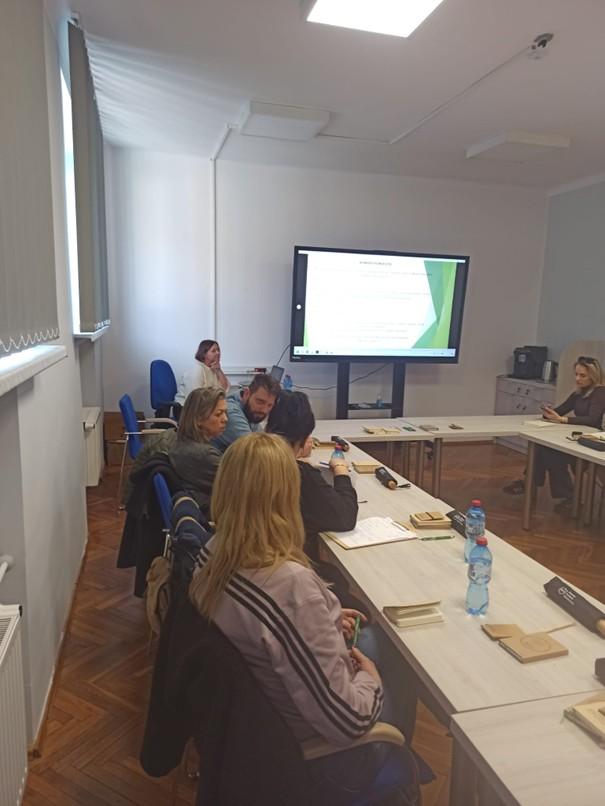 Fotografia wykonana podczas spotkania dotyczącego Krajowego Funduszu Szkoleniowego. Przedstawia sale, w której osoby zainteresowane obserwowały prezentacje dotyczącą uzupełniania wniosku KFS.