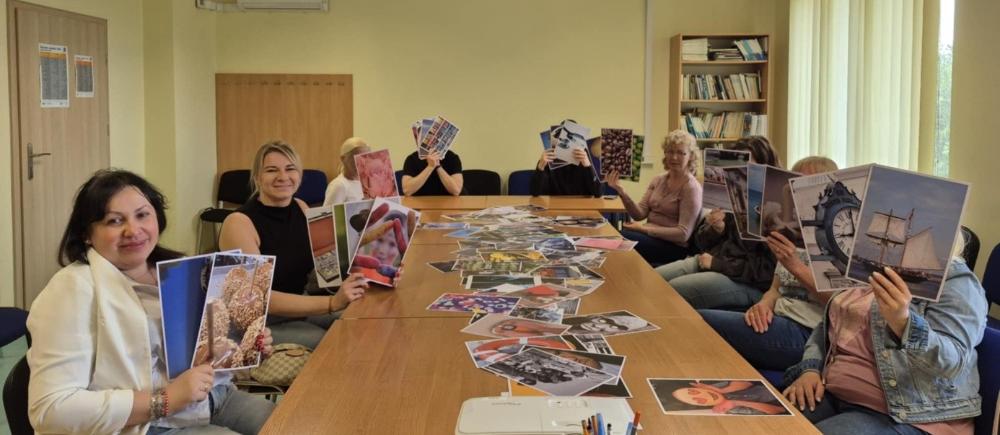 Fotografia wykonana podczas warsztatów „Kompetencje  miękkie czyli co pracodawcy cenią  najbardziej", przedstawia salę spotkań grupowych a w niej uczestniczki pracujące przy wspólnym stole.